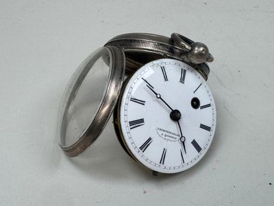 une horloge en argent dont le cadran est orné de chiffres romains