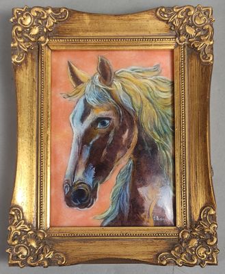 un tableau représentant un cheval, dans un cadre doré, accroché au mur
