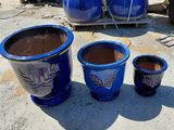 three blue pots sitting next to each other on the ground