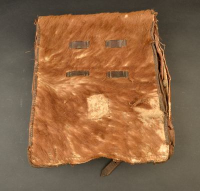 an old leather book with fringes on it sitting on a table
