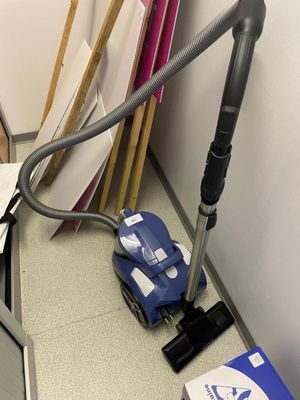 un aspirateur posé sur un bureau, à côté d'une pile de papiers
