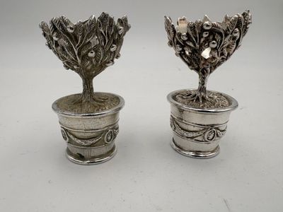 pair of silverplated vases with flowers and leaves in them