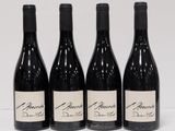 four bottles of wine are lined up on a white surface