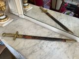 two swords sitting on a marble counter in front of a mirror