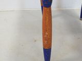 an old wooden chair with blue legs and a wooden seat