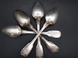 five spoons arranged in a circle on a black surface