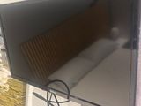 a flat screen tv hanging on a wall next to a bed
