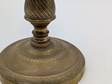 a small brass candle holder on a white table