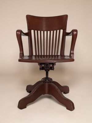 une image représentant une chaise en bois posée sur un socle, avec une assise en cuir marron