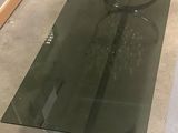 a glass table with a metal base and a glass top
