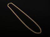 un collier en or avec une chaîne sur fond noir