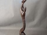 statue en bronze d'une femme tenant un oiseau sur une base en bois