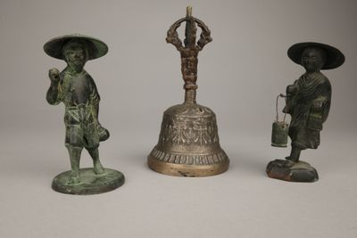 three bronze figurines of asian men with hats and umbrellas