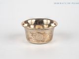 a small silver bowl sitting on a white surface