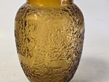 un vase en verre jaune orné d'un motif représentant un arbre