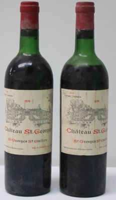 two bottles of red wine sitting next to each other on a table