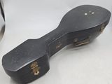 an old black guitar case sitting on top of a white table