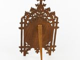 an old wooden clock with a cross on it and a wooden stick sticking out of it