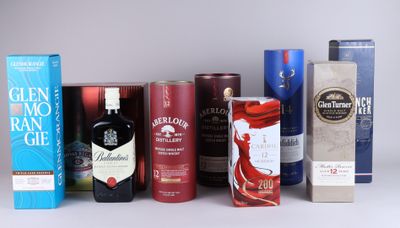 many different types of alcohol bottles and boxes on the table