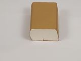 un petit livre marron posé sur une surface blanche