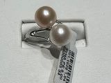 une bague ornée de deux perles, exposée dans une vitrine