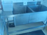 two sinks in the kitchen with a trash can and a trash can