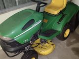a green and yellow lawn mower parked in a garage