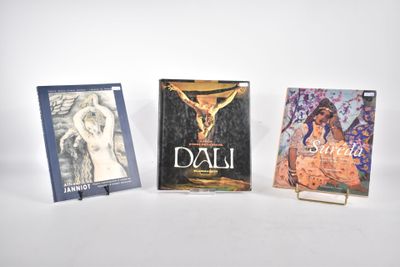 trois livres posés les uns à côté des autres sur une surface blanche