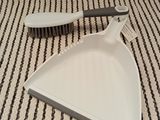a dust pan and a brush on a striped table cloth