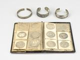 an open book with a bunch of silver rings on top of it