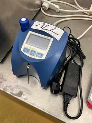 un appareil bleu et blanc posé sur un comptoir à côté d'un téléphone portable