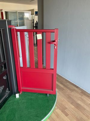 une porte rouge avec un paillasson vert au milieu