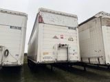 deux semi-remorques blanches garées côte à côte dans un champ