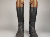 une paire de bottes en cuir marron et noir, avec des boucles de chaque côté