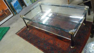 une table basse en verre posée sur un tapis dans une pièce