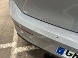 a silver car parked in a parking lot next to a parking meter
