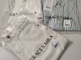 three shirts in plastic bags sitting on top of a table