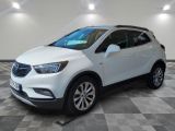 un SUV Buick blanc garé dans une grande pièce