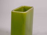 a green vase with a square design on it