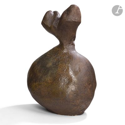 un vase brun posé sur une surface blanche