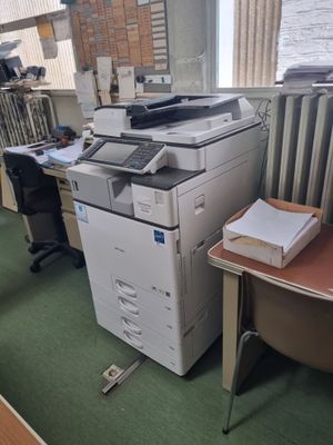 un bureau avec une imprimante et une chaise dans une pièce