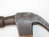 a hammer that is sitting on top of a piece of wood