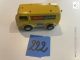 un petit camion jaune en plastique posé à côté d'une feuille de papier bleue
