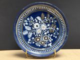 une assiette bleue et blanche ornée d'un motif floral