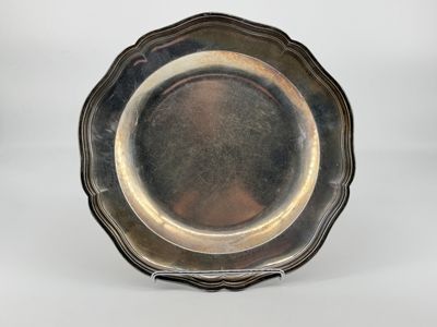 an antique silver plate on a stand on a white background