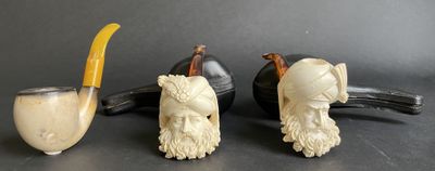 trois figurines d'animaux et une pipe posées sur une table