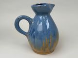 a blue and yellow pitcher sitting on a white surface