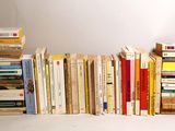 many books stacked on top of each other on a table