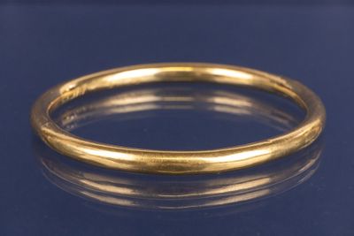 un gros plan d'une bague en or sur une surface bleue