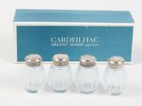three glass salt and pepper shakers with a box in the background
